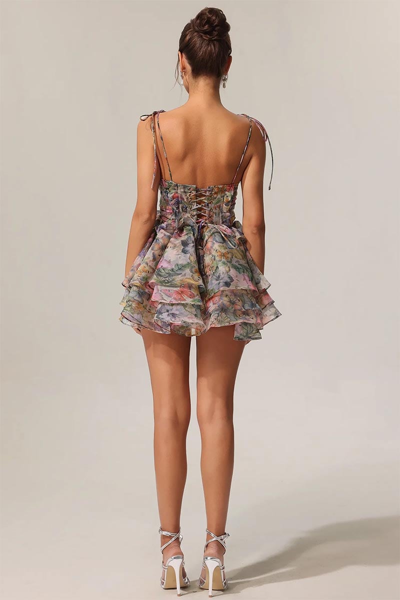 Woman wearing a floral dress with thin straps on a plain background | Evelina Floral Print Mini Dress | Jewelclues